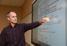 Male ECE faculty at smart board in classroom