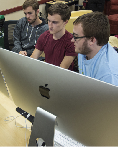 students sitting before computer screens
