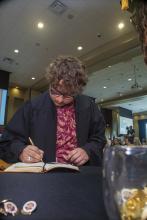 Student robed, then signs Freshmen Book