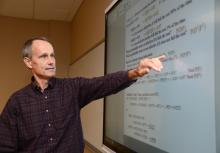 Male ECE faculty at smart board in classroom