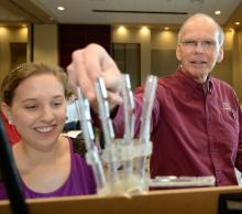 Male ECE faculty and female student displaying mechanical hand